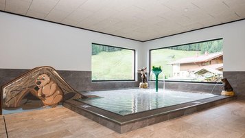 Kinderbecken mit bunten Tierfiguren und Wasserspielen im Familienhotel Oberkarteis.
