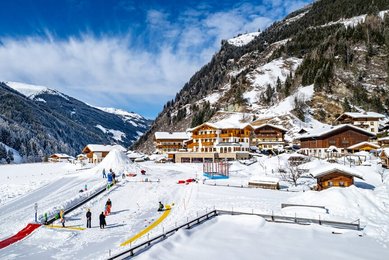 Winter Aufnahme von der Landschaft und der Kinderskischule vom Familienhotel Oberkarteis im Salzburger Land.