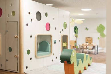Spielerisch gestaltetes Indoor-Spielhaus mit bunten Elementen und Sitzmöglichkeiten im Familienhotel Oberkarteis.