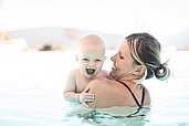 Mutter mit ihrem Baby im Pool im Family Home Alpenhof in Südtirol