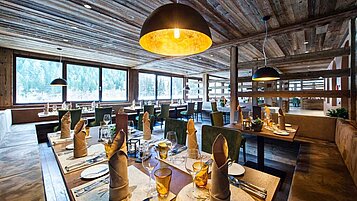 Genütlich eingerichtetes Restaurant mit großen Panoramafenstern im Familienhotel Alphotel Tyrol Wellness & Family Resort in Südtirol.