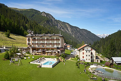 Hotelansicht im Sommer auf die ganze Hotelanlage im Familienhotel Bella Vista in Südtirol.