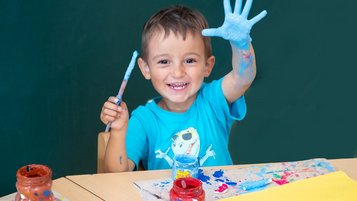 Junge beim Malen in der liebevollen Kinderbetreuung des Familienhotels Der Ponyhof in der Steiermark.