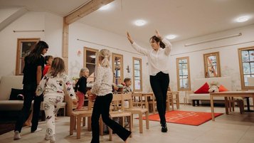 Kinder bewegen sich gemeinsam mit einer Kinderbetreuung im Happy-Club des Hotel Sonngastein im Salzburger Land.