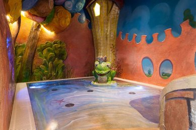 Verspieltes Kinderbecken mit Froschkönig-Brunnen im Familienhotel Bavaria.