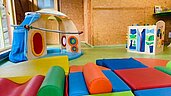 Babyspielzimmer mit Softplayboden und kindgerechten Spielsachen im Familienhotel Family Club Harz.