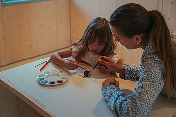 Mutter und Tochter malen gemeinsam im Happy-Club des Familienhotels Engel Gourmet & Spa
