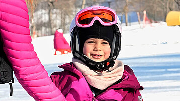 Mädchen in Skiausrüstung auf der Skipiste im Bayerischen Wald.