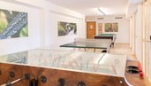 Heller Freizeitraum mit Tischtennisplatte, Tischkicker und Billardtisch im Familienhotel Ramsi in Kärnten