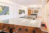 Heller Freizeitraum mit Tischtennisplatte, Tischkicker und Billardtisch im Familienhotel Ramsi in Kärnten