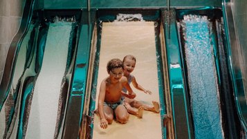 Zwei Kinder haben fröhlichen Rutschenspaß im Familienhotel Oberkarteis und genießen das Wasserabenteuer.