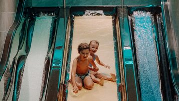 Zwei Kinder haben fröhlichen Rutschenspaß im Familienhotel Oberkarteis und genießen das Wasserabenteuer.