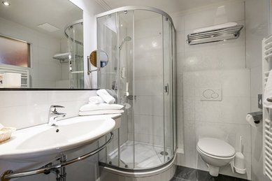 Modern ausgestattetes Badezimmer im Familienhotel Zauchenseehof im Salzburger Land mit Dusche, WC und großzügigem Waschbereich.
