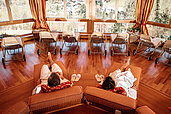 Eltern entspannen auf einer Liege im Wellnessbereich des Familienhotels Kirchheimerhof in Kärnten.