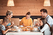 Familie beim gemeinsamen Frühstück im Family Home Alpenhof.