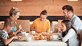Familie beim gemeinsamen Frühstück im Family Home Alpenhof.