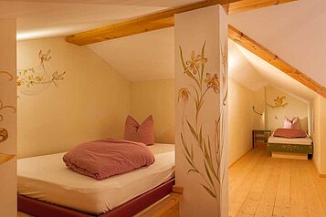 Das gemütliche Kinderzimmer mit zwei Betten im Familienhotel Alphotel Tyrol Wellness & Family Resort in Südtirol.