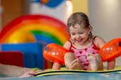 Wasserspaß im Familienurlaub im Familienhotel Mein Krug. Ein Mädchen im Indoorpool beim spielen im Wasser.
