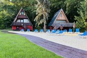 Outdoor-Pool mit Liegewiese und A-förmigen Häusern im Family Club Harz.