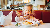 Mädchen isst Spagetti im Restaurant des Familienhotels Kirchheimerhof in Kärnten.