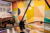 Ein Spielebereich mit Tischfußball, Basketballkorb und farbig gestalteter Wand im Wellness- & Familienhotel Egger im Salzburger Land.