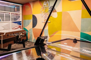 Ein Spielebereich mit Tischfußball, Basketballkorb und farbig gestalteter Wand im Wellness- & Familienhotel Egger im Salzburger Land.