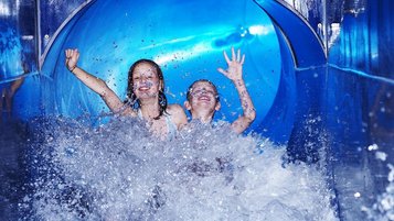 Zwei Kinder beim Rutschen in einer Wasserrutsche im Familienhotel Feldberger Hof im Schwarzwald