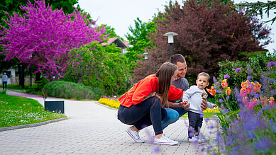Familie mit Kind im Garten im Familienhotel Kolping Hotel Spa & Family Resort in Ungarn.