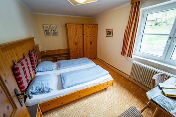 Rustikales Familienzimmer mit Doppelbett und Holzmöbeln im Familienhotel Bruckwirt.