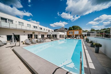 Der große Outdoorpool mit Liegebereich gehört zu den Highlights im Familienhotel Friedrichshof.