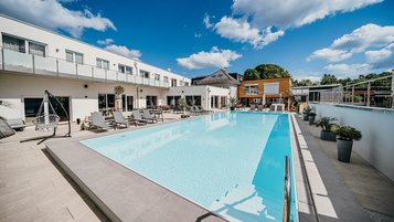 Der große Outdoorpool mit Liegebereich gehört zu den Highlights im Familienhotel Friedrichshof.