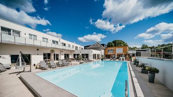 Der große Outdoorpool mit Liegebereich gehört zu den Highlights im Familienhotel Friedrichshof.