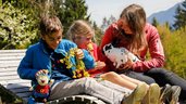 Kinder streicheln ein Kaninchen auf der Sonnenliege beim Familienhotel Ramsi