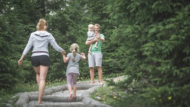 Familie im Sommer in der Natur mit zwei Kindern im Alphotel Tyrol Wellness & Family Resort in Südtirol.