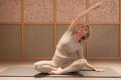 Eine Frau macht Yoga und Dehnuebungen in einem ruhigen Entspannungsbereich im Hotel Bella Vista in Südtirol.