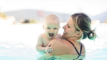 Mutter mit ihrem Baby im Pool im Family Home Alpenhof in Südtirol