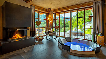 Wohnbereich mit eigenem Indoor Whirlpool und Hot Tub auf der Terrasse im Mons Silva Private Luxury Chalet.