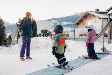 Kinder lernen Skifahren im Mini Skiclub beim Familienhotel Amiamo im Salzburger Land.