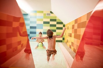 Kinder planschen im Kinderbecken des Familienhotels Alpenhof Dolomit Family