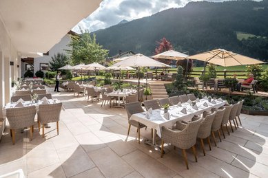 Sonnige Terrasse mit stilvoll gedeckten Tischen im Familienhotel Kindl.