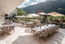 Sonnige Terrasse mit stilvoll gedeckten Tischen im Familienhotel Kindl.