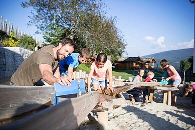 Kinder spielen auf dem Outdoorspielplatz im Urlaub im Family Home Alpenhof in Südtirol..