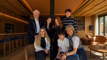Die Gastgeberfamilie Thöni sitzt im Familienhotel Bella Vista in Südtirol gemeinsam in der gemütlichen Hotellounge.