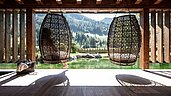 Eltern sitzen im Wellness-Ruhebereich und genießen die Panoramaaussicht vom Familienhotel Alphotel Tyrol Wellness & Family Resort.