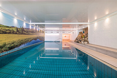 Indoor Schwimmbad mit heller Beleuchtung im Familienhotel Kirchheimerhof in Kärnten.