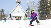 Kind beim Skifahren im Familienurlaub im Schwarzwald.