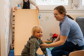 Zwei Kleinkinder spielen gemeinsam mit der Kinderbetreuerin im Happy-Club im Familienhotel