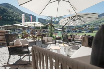 Ein Blick auf die Sonnenterrasse mit Aussicht in die Berge im Familienhotel Gorfion in Liechtenstein