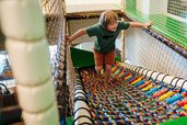 Junge tobt im bunten Indoor-Spielbereich des Familien Resort Petschnighof in Kärnten.