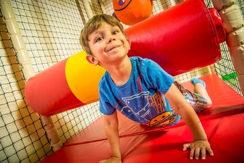 Junge spielt im Indoor-Kletterbereich im Landgut Furtherwirt